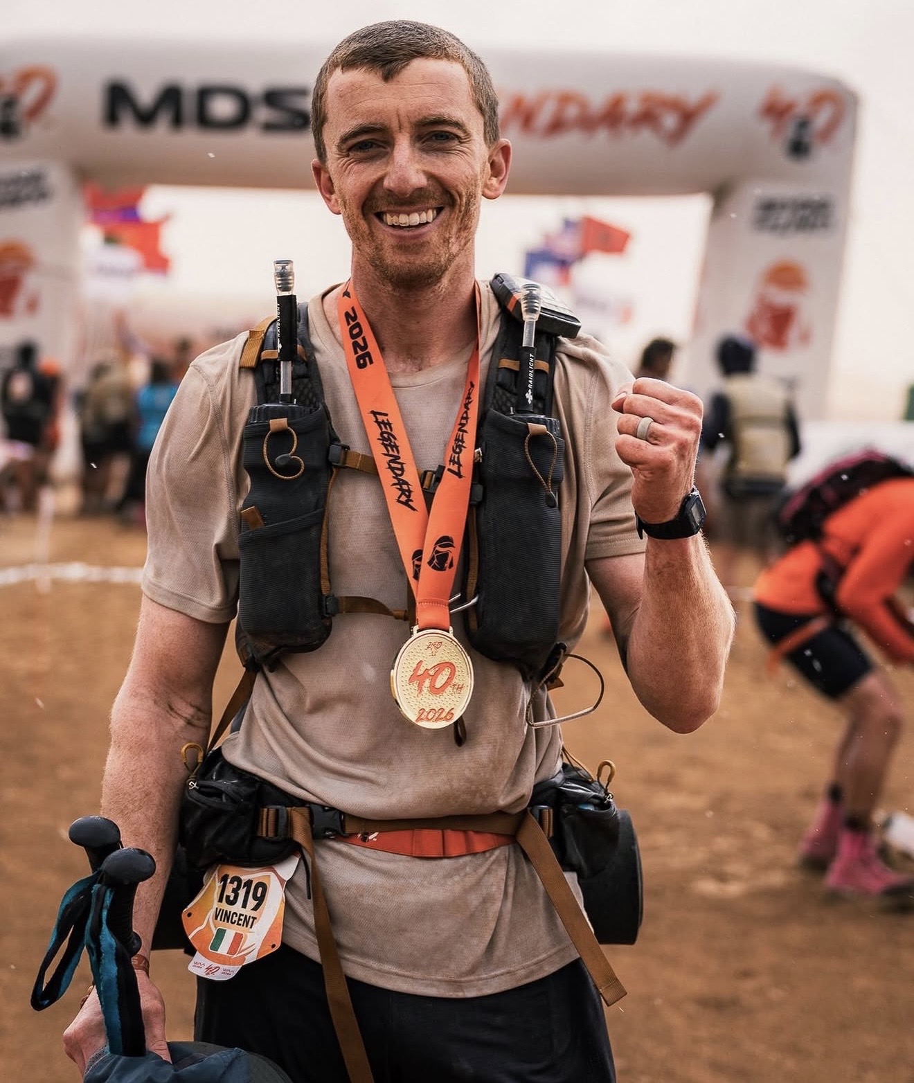 Vinny smiling at the Marathon des Sables finish line with his medal